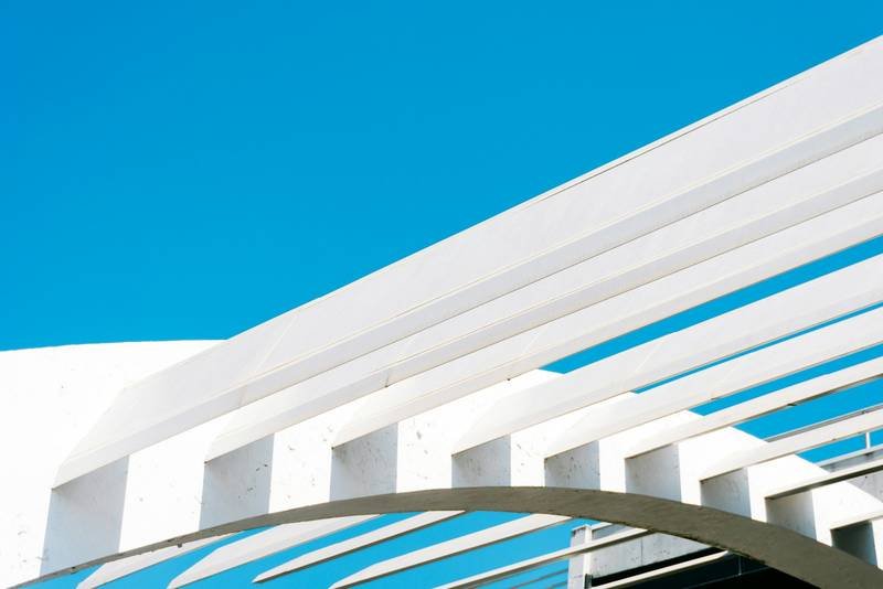 Lames blanches d’une pergola sur ciel bleu