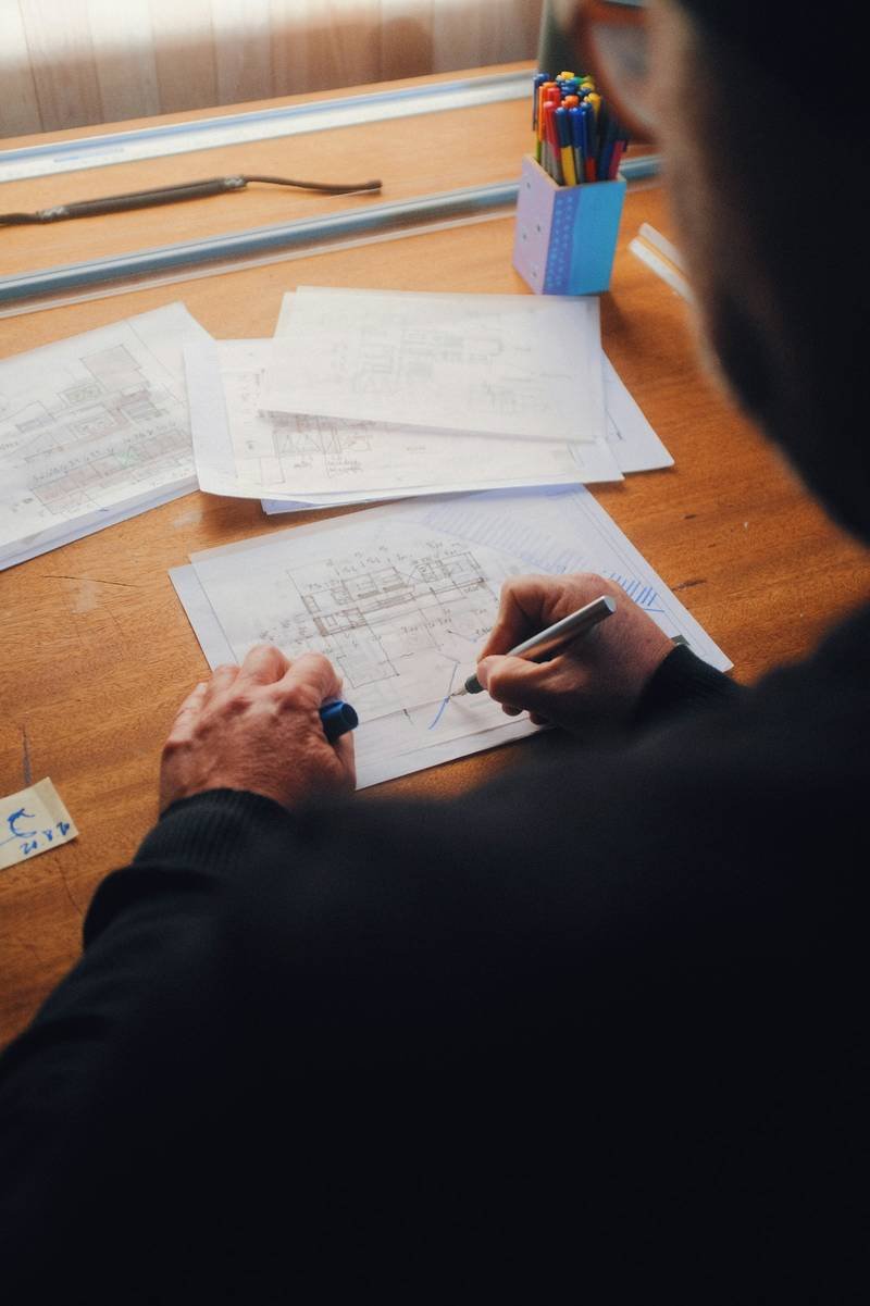 Mains annotant des plans techniques